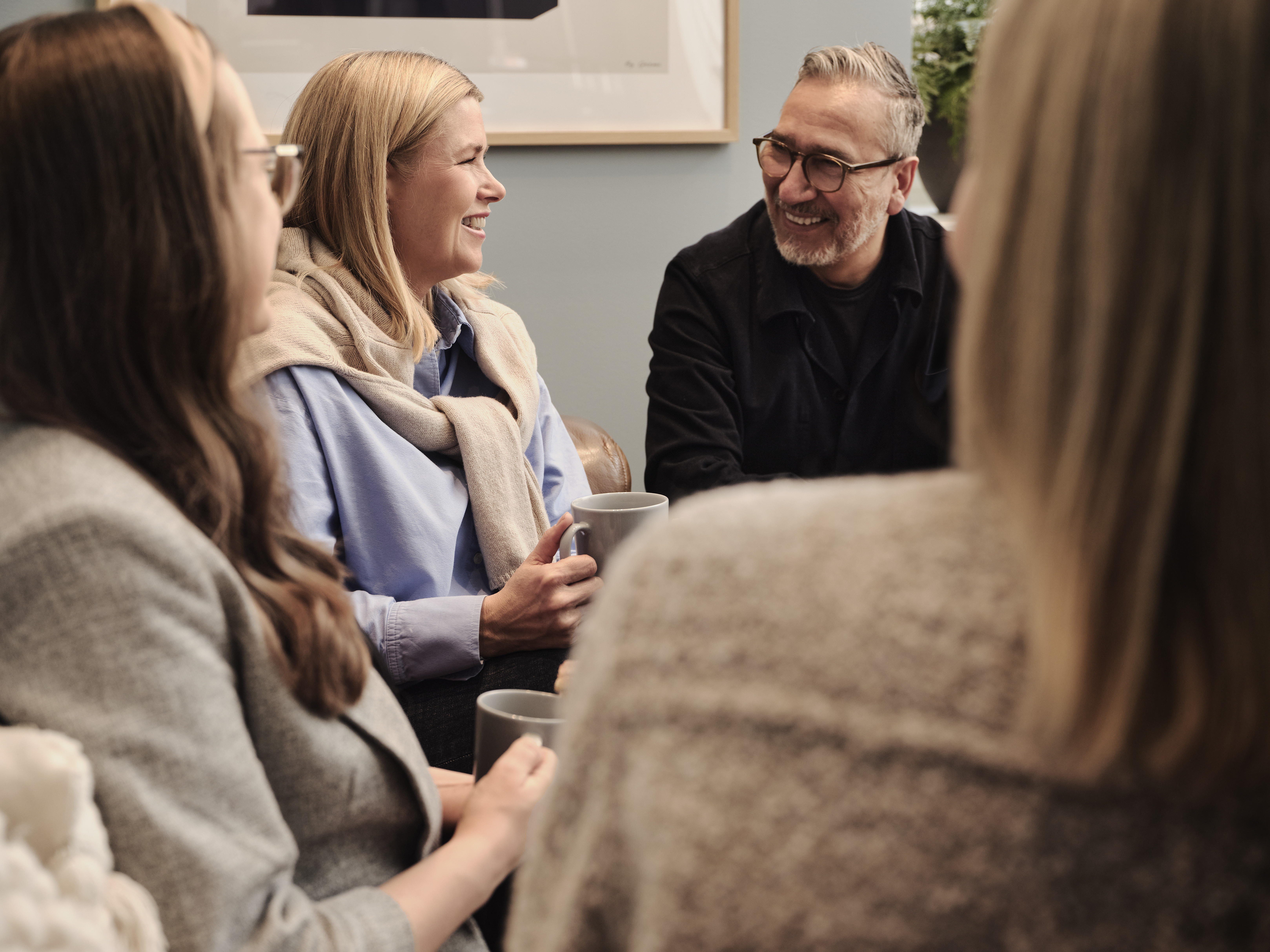 En grupp människor som sitter runt ett bord och pratar.