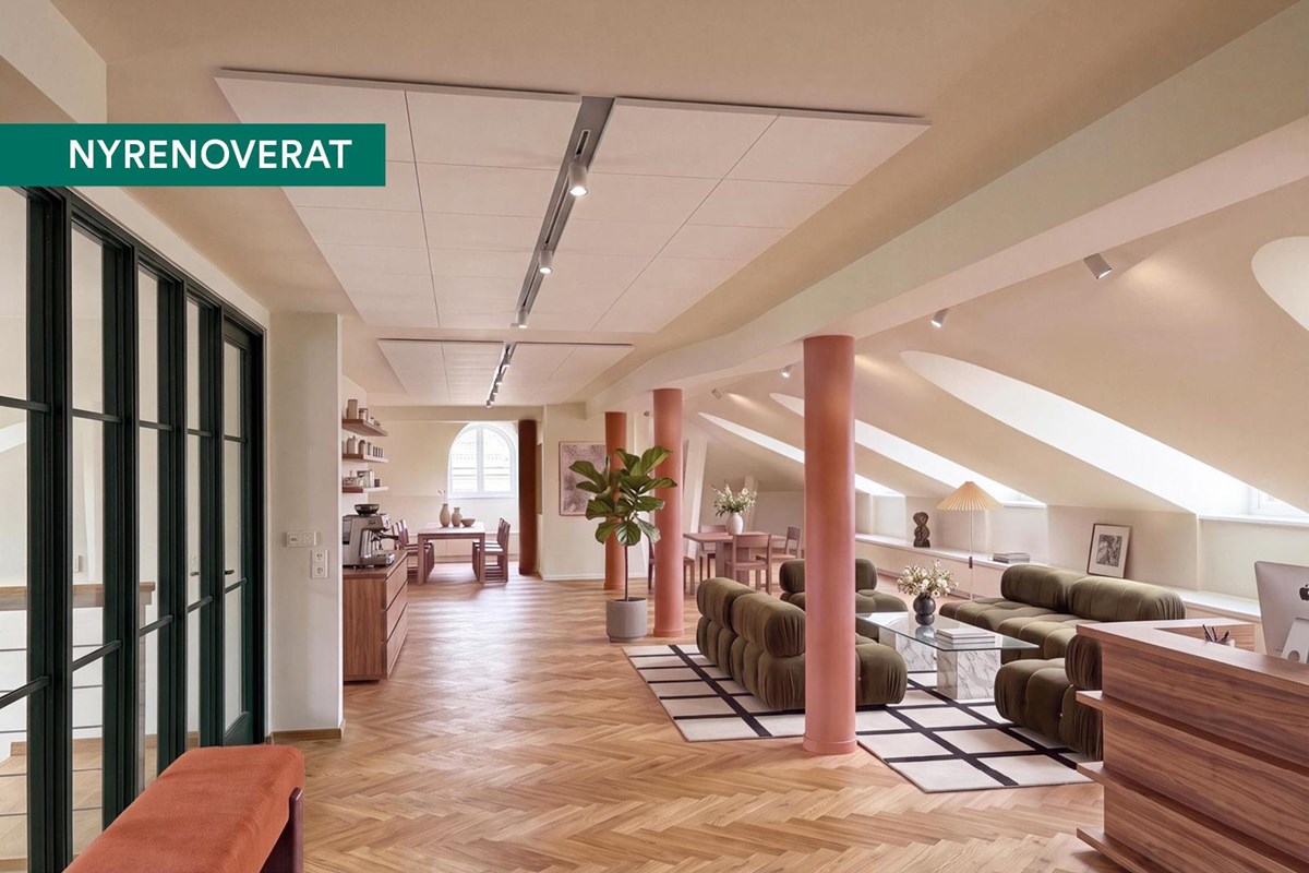 Visionsbild av en nyrenoverad entré med reception, loungeyta, trägolv, stora takfönster och modern i
